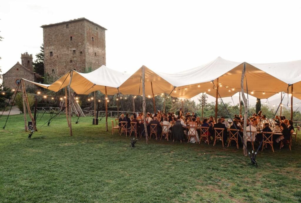 Rustic wedding banquet setup at Castello di Ristonchi, featuring candlelit tables and a magical outdoor dining experience. Captured by Wild Silk Visuals