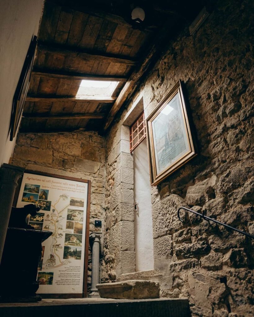 Bride walking through the ancient stone archways of Castello di Ristonchi, blending historic charm with timeless romance. Photography by Wild Silk Visuals.