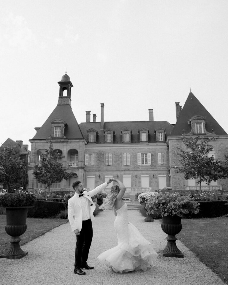 Standing before the historic château, the newlyweds share a moment of love and happiness at Domaine d'Essendieras.
