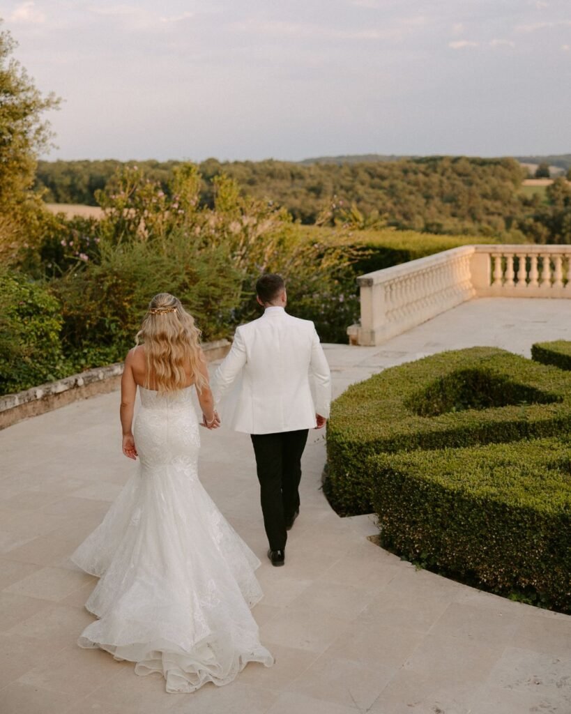 The couple shares an intimate moment on the venue's terrace, overlooking the stunning countryside at Domaine d'Essendieras.