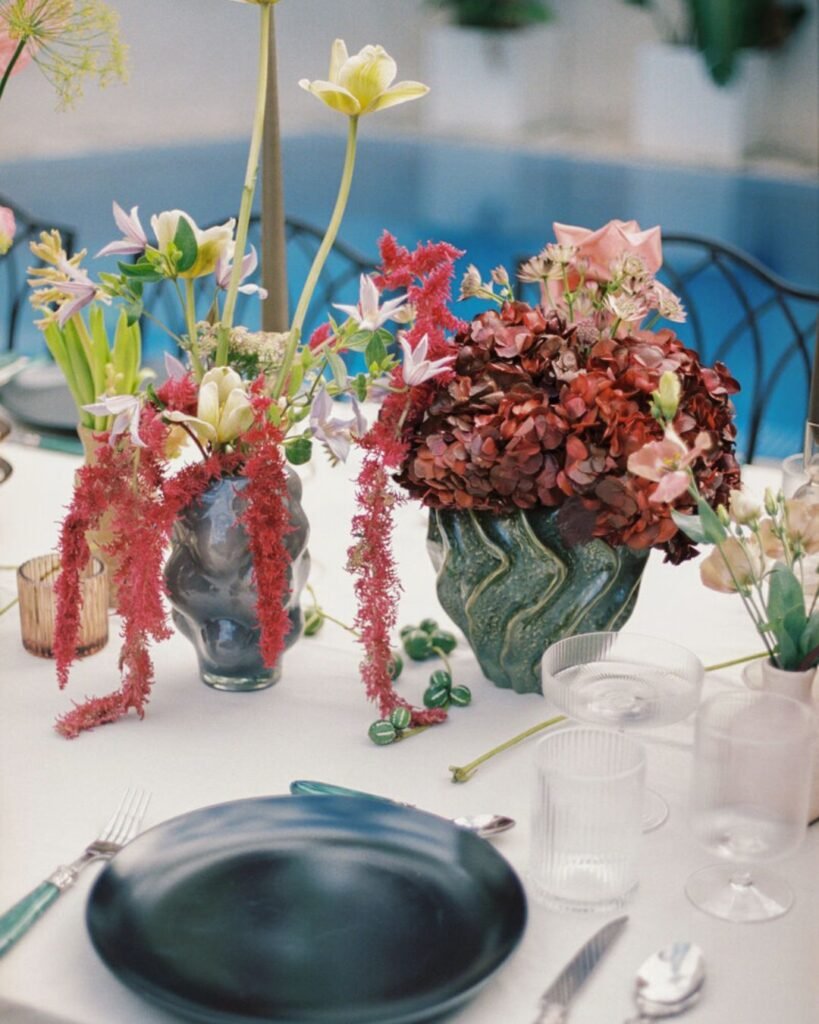 A close-up of the wedding table decor at Masia Victoria, showcasing delicate flowers, candles, and fine tableware.