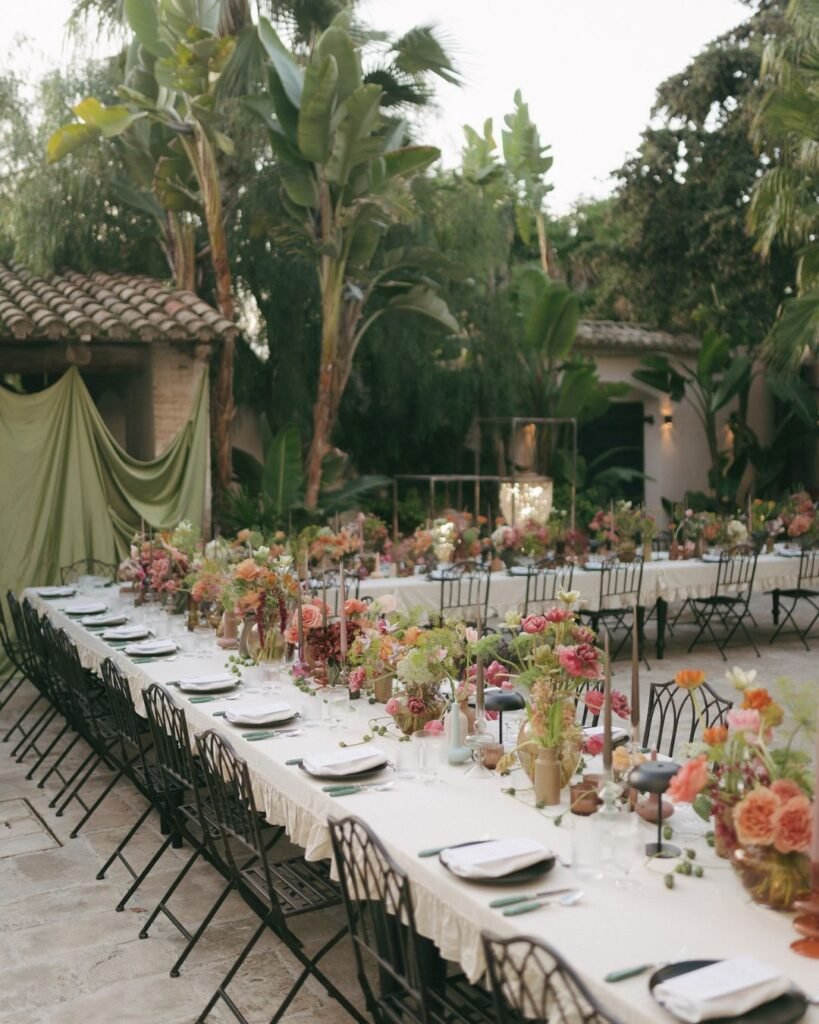 A beautifully arranged rustic wedding table setup at Masia Victoria, featuring elegant floral centerpieces and candlelit ambiance.