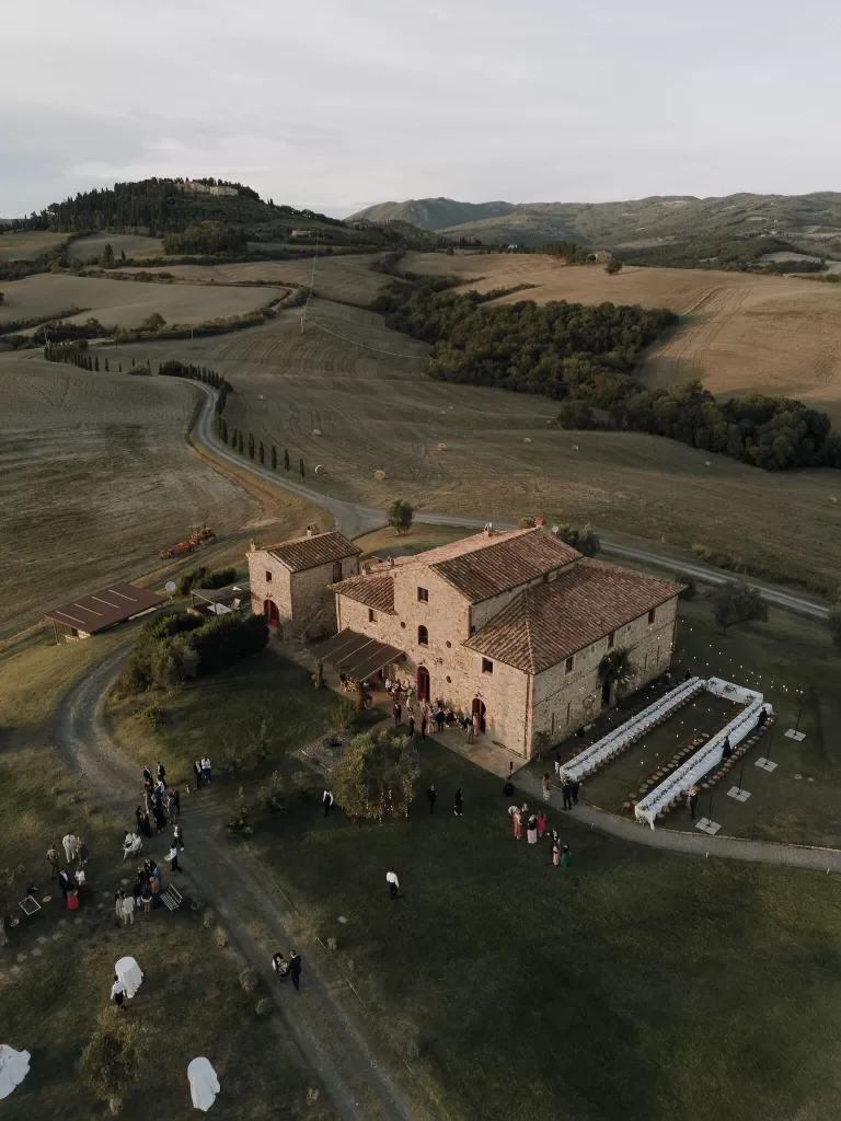 Drone photo of Podere Calvaiola surrounded by golden Tuscan countryside during an autumn wedding celebration.
