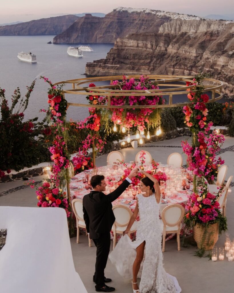 The bride and groom posing at sunset at Venetsanos Winery, with golden light reflecting on the Aegean Sea.