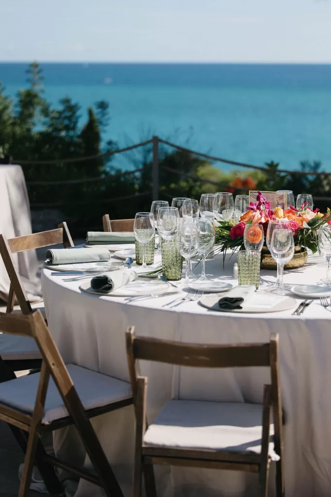 Elegant reception table with ocean backdrop and colorful floral centerpiece at Masia Casa del Mar.