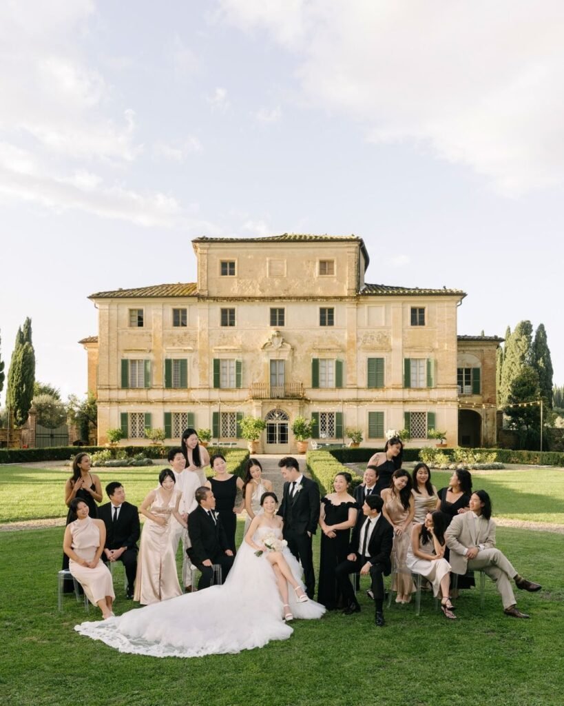 Grand entrance to a wedding at Villa di Geggiano, adorned with floral arrangements and classic Italian architecture, captured by Liza Litvinovich.