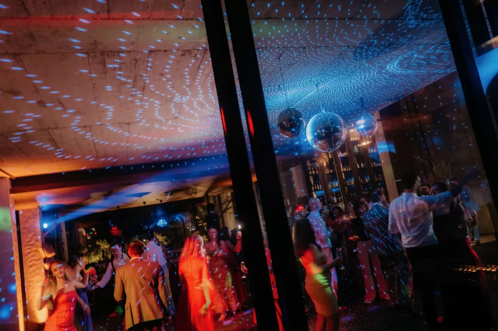 Wedding guests dancing under disco lights inside Areias do Seixo, capturing the energy of the evening celebration.