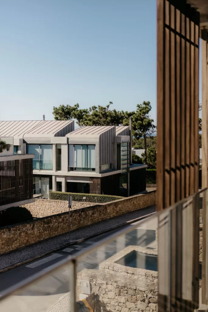 Contemporary guest villas at Areias do Seixo overlooking landscaped grounds under a clear blue sky.
