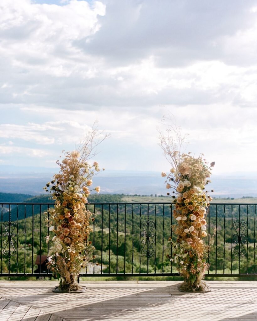 Rustic wedding altar adorned with flowers and greenery at Whispering Oaks Ranch, photographed by Kayla Bertagnolli.