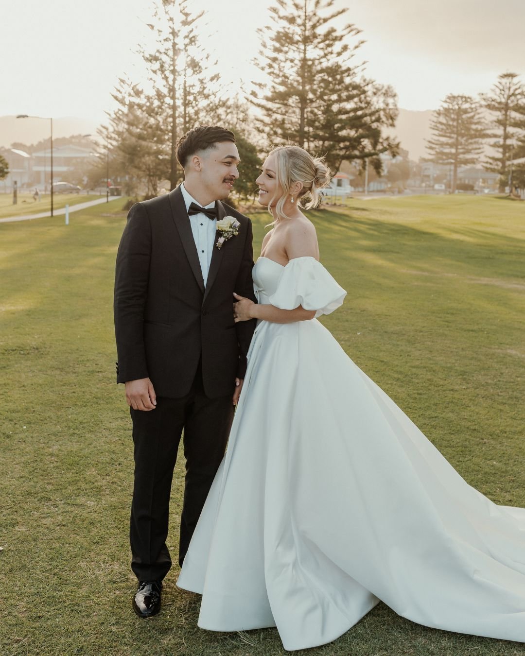A bride and groom twirl joyfully on a garden pathway, lost in their first dance, captured by Bella Weddings