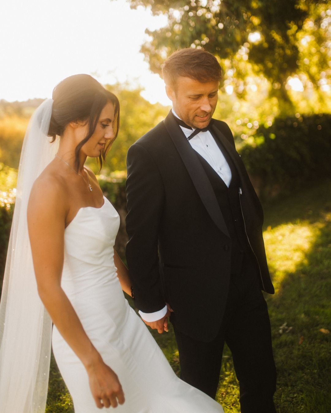 Bride and groom bathed in golden light during a sunset portrait.