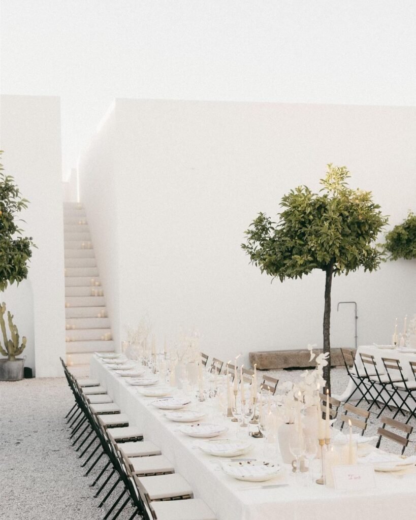 A beautifully set wedding table at Masseria Morosetta, adorned with candles, white linens, and rustic floral arrangements for an elegant outdoor reception.