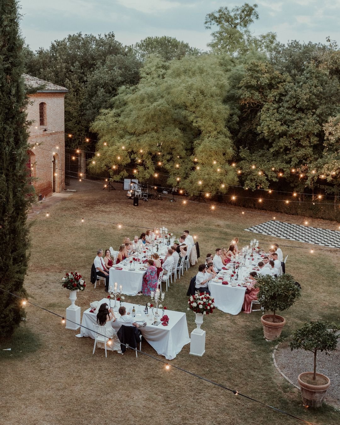 A beautifully arranged wedding table outdoors, with delicate glassware and romantic florals, captured by Bella Weddings.