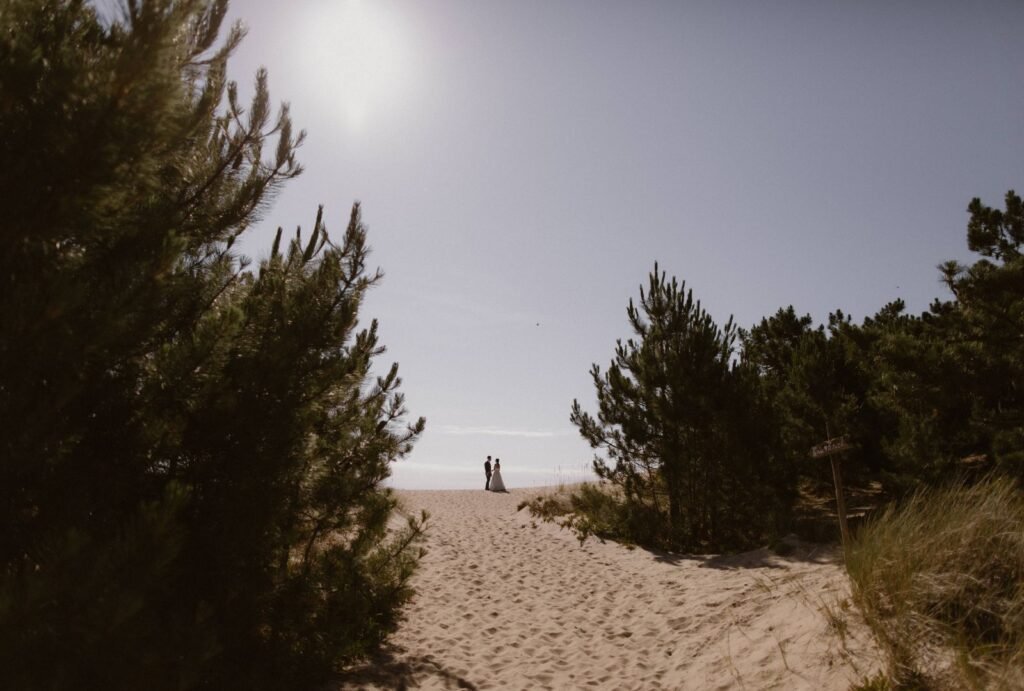 The couple shares a kiss on the secluded beach near Areias do Seixo, surrounded by the raw beauty of nature.