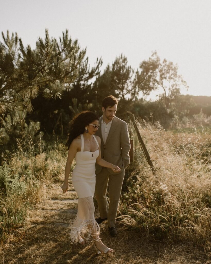 A windswept moment on the beach as the bride’s dress flows in the breeze, creating a dreamy and cinematic scene.