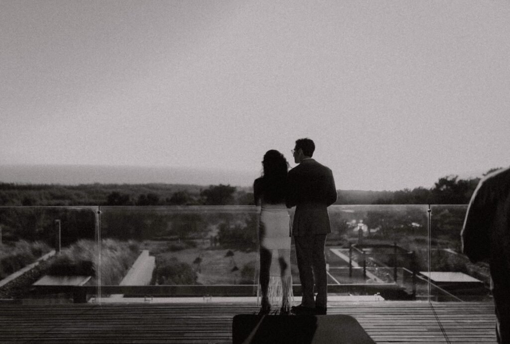 A romantic moment on the terrace of Areias do Seixo, where the couple shares a quiet embrace with the scenic backdrop.