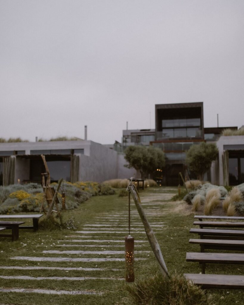 A peaceful garden pathway at Areias do Seixo, lined with lush greenery leading towards the venue’s entrance.