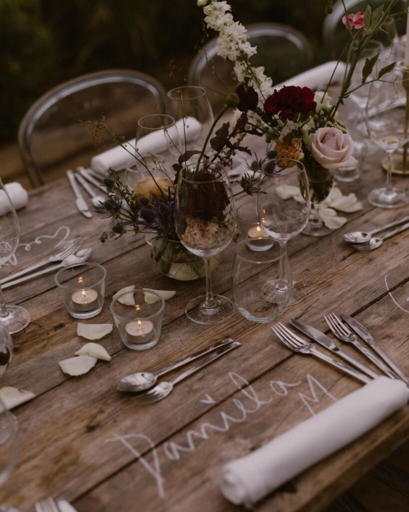 A close-up of table decor at Areias do Seixo, featuring softly glowing candles, delicate florals, and textured linens.