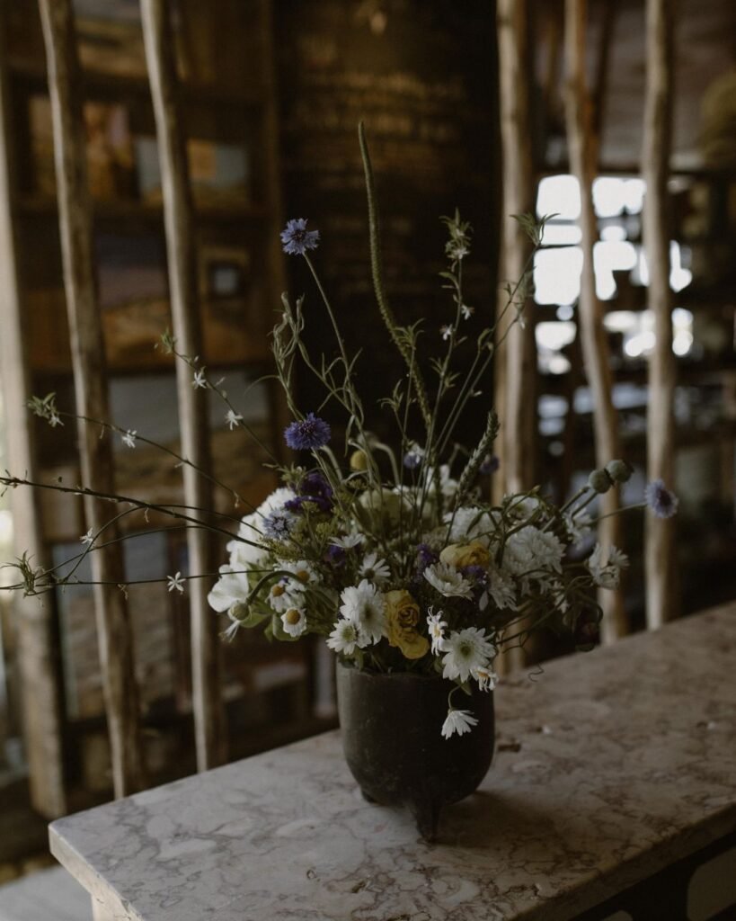 A simple yet elegant vase with fresh flowers, adding a natural and romantic touch to the wedding decor at Areias do Seixo.