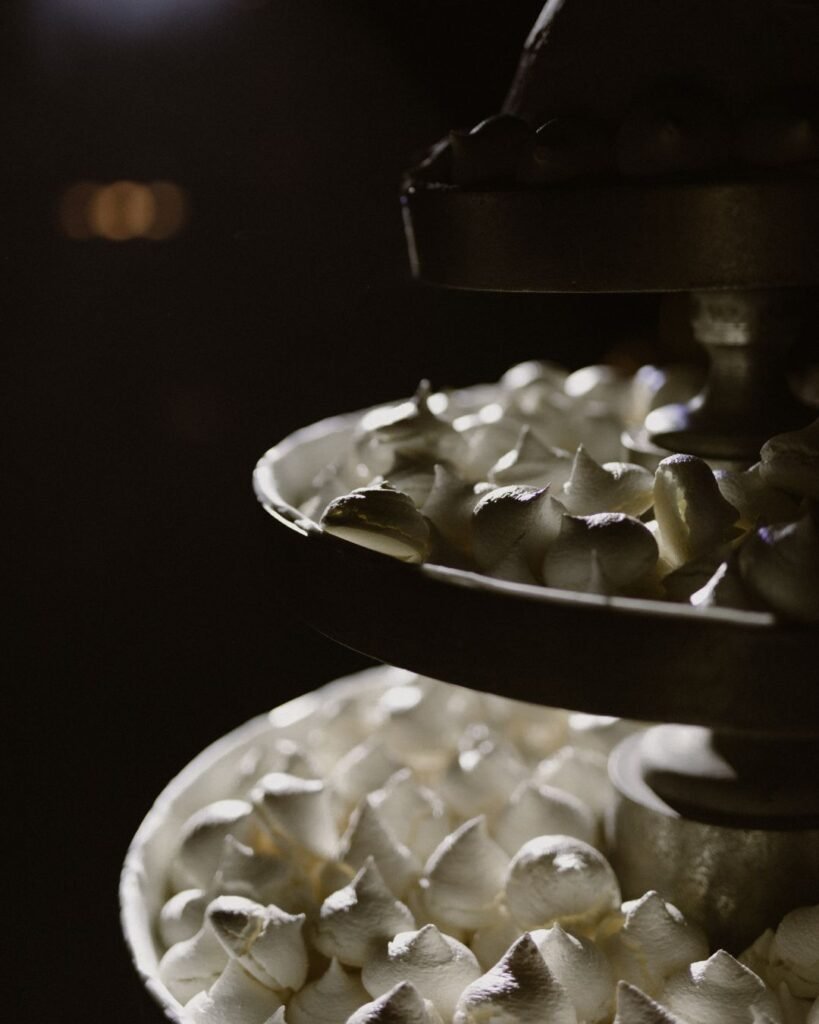 A detailed view of the wedding cake, showcasing intricate textures and soft, romantic decorations.