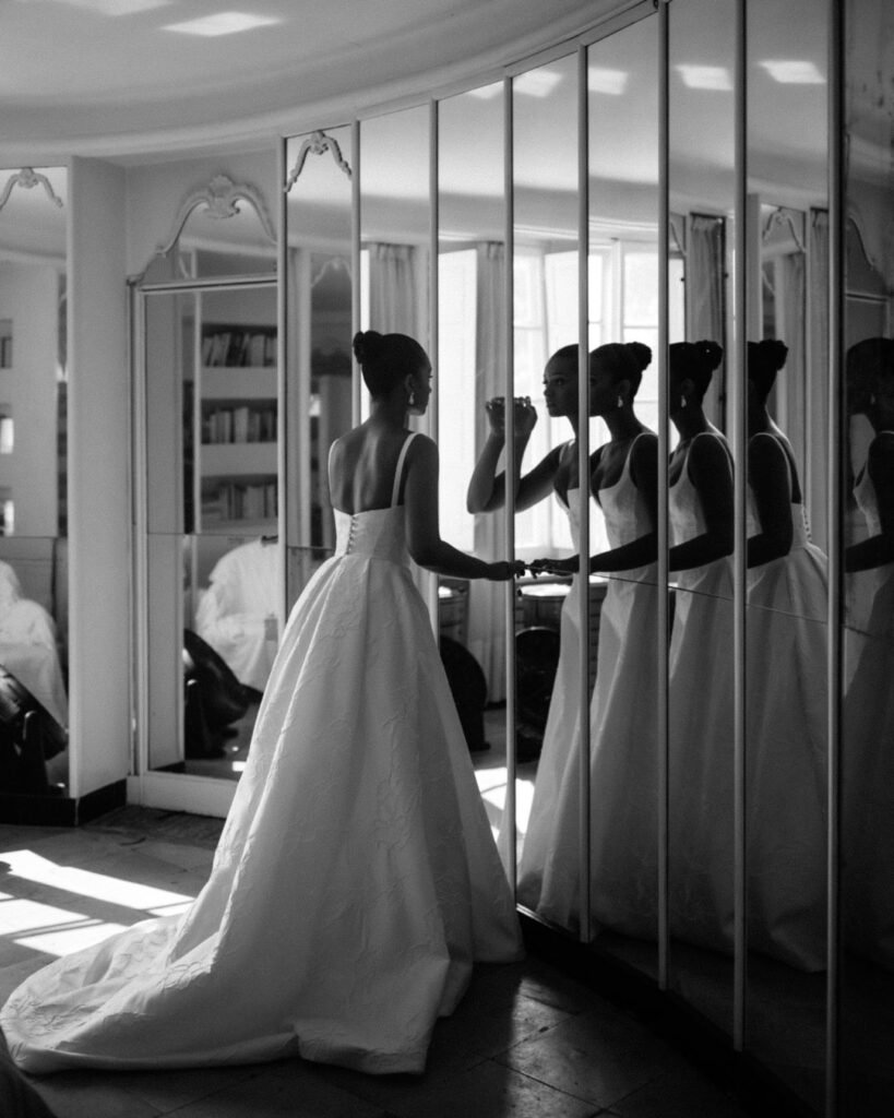 Bride gazing into the mirror at Bastide du Roy, capturing a quiet moment before the ceremony.