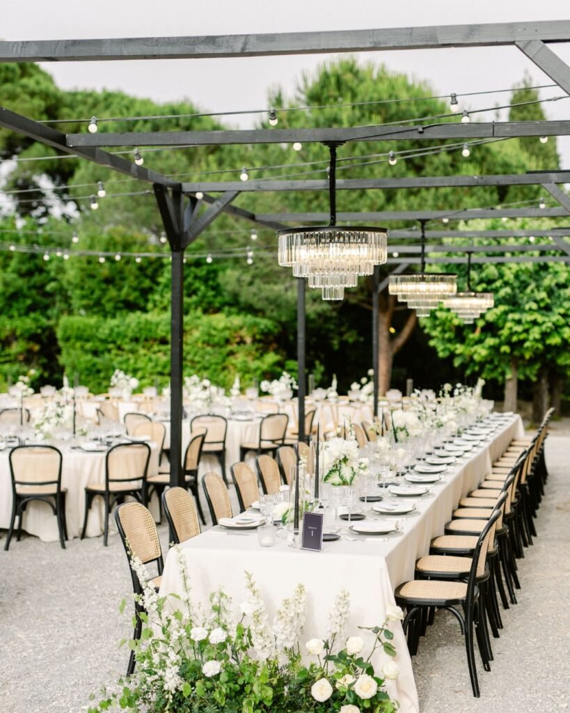 Charming outdoor reception setup at Bastide du Roy, with long banquet tables under twinkling string lights.