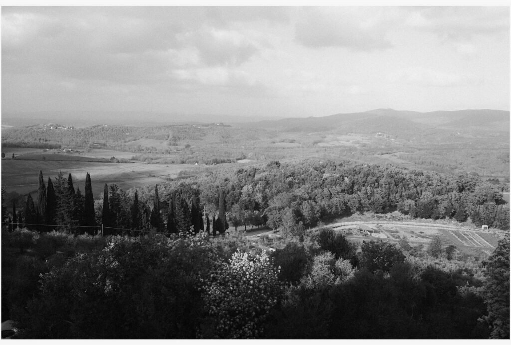 A black and white landscape view from Rosewood Castiglion del Bosco, capturing rolling Tuscan hills in dramatic contrast.