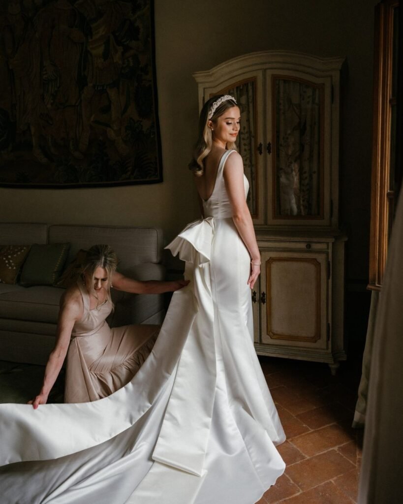 The bride in a sunlit suite at Rosewood Castiglion del Bosco, putting on earrings before the ceremony.