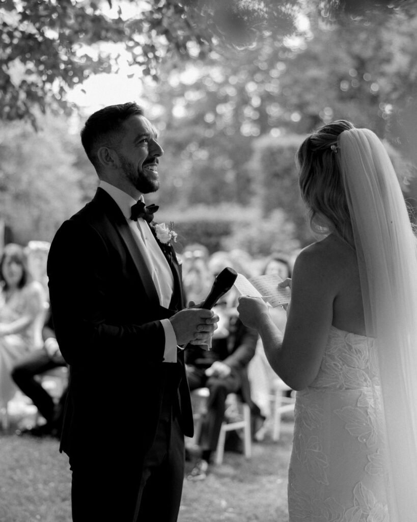 A heartfelt moment during the ceremony as the couple stands together under a stunning floral arch at Domaine d'Essendieras.