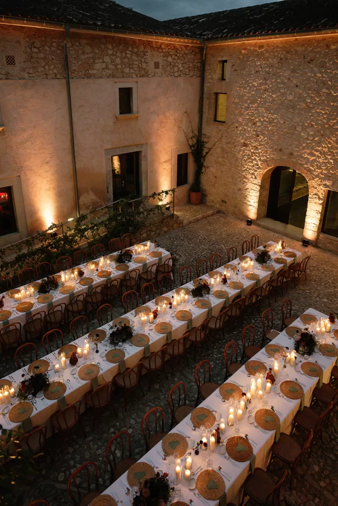 Candlelit reception tables set in stone courtyard at Finca Morneta at dusk