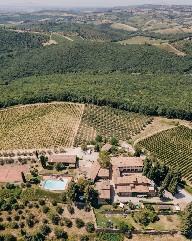 A sweeping aerial shot of Quercia al Poggio, showcasing its historic estate and surrounding vineyards.