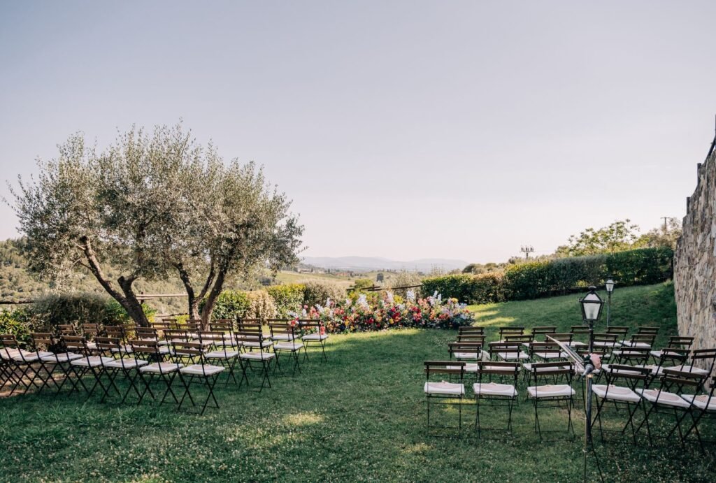 A beautiful outdoor ceremony setup at Quercia al Poggio, with wooden chairs neatly arranged under the Tuscan sky.