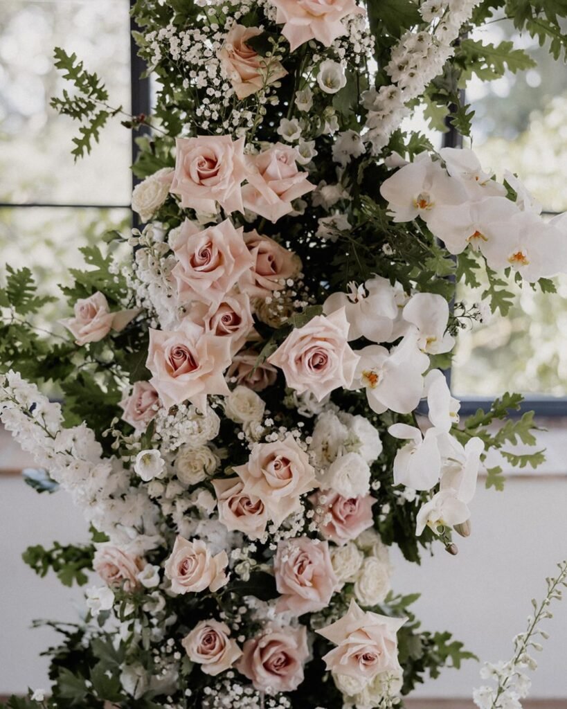A lush floral arch intertwined with greenery, framing the ceremony space at Quercia al Poggio.