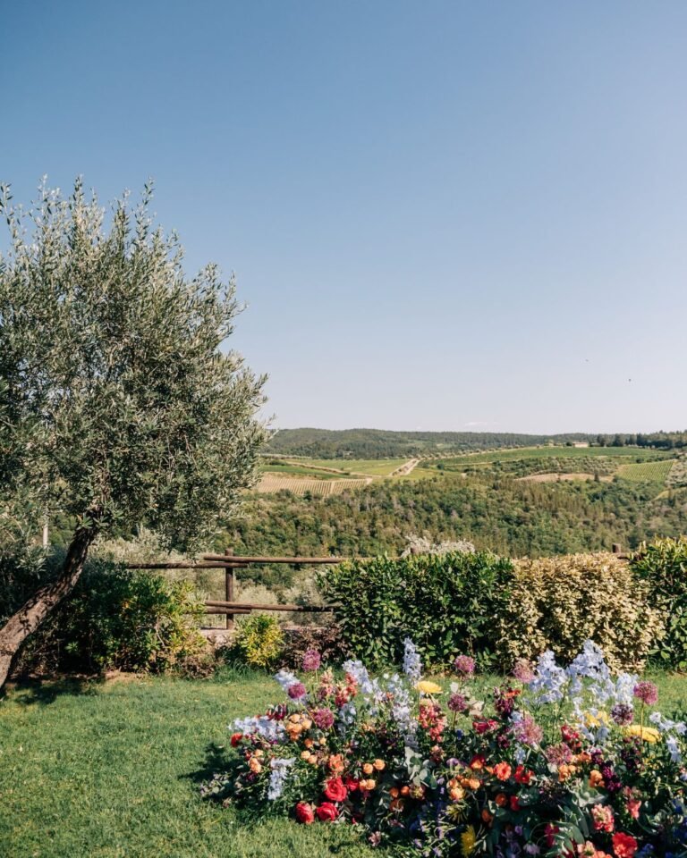 Elegant floral arrangements on the ground frame the wedding altar at Quercia al Poggio.
