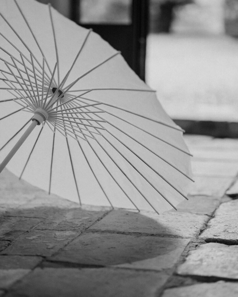 A close-up of a white ceremony umbrella at Quercia al Poggio, providing elegant shade for guests.
