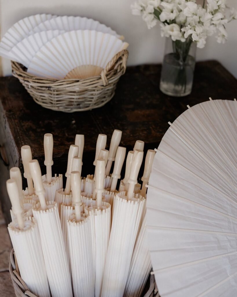 White umbrellas shading the ceremony seating at Quercia al Poggio’s sunlit vineyard wedding.