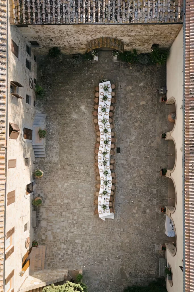Overhead view of the stone courtyard at Quercia al Poggio set for an intimate outdoor dinner.