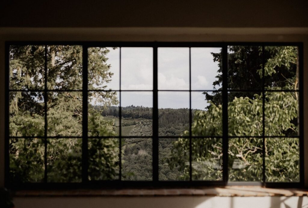 A dreamy view of the rolling Tuscan hills through an old villa window at Quercia al Poggio.