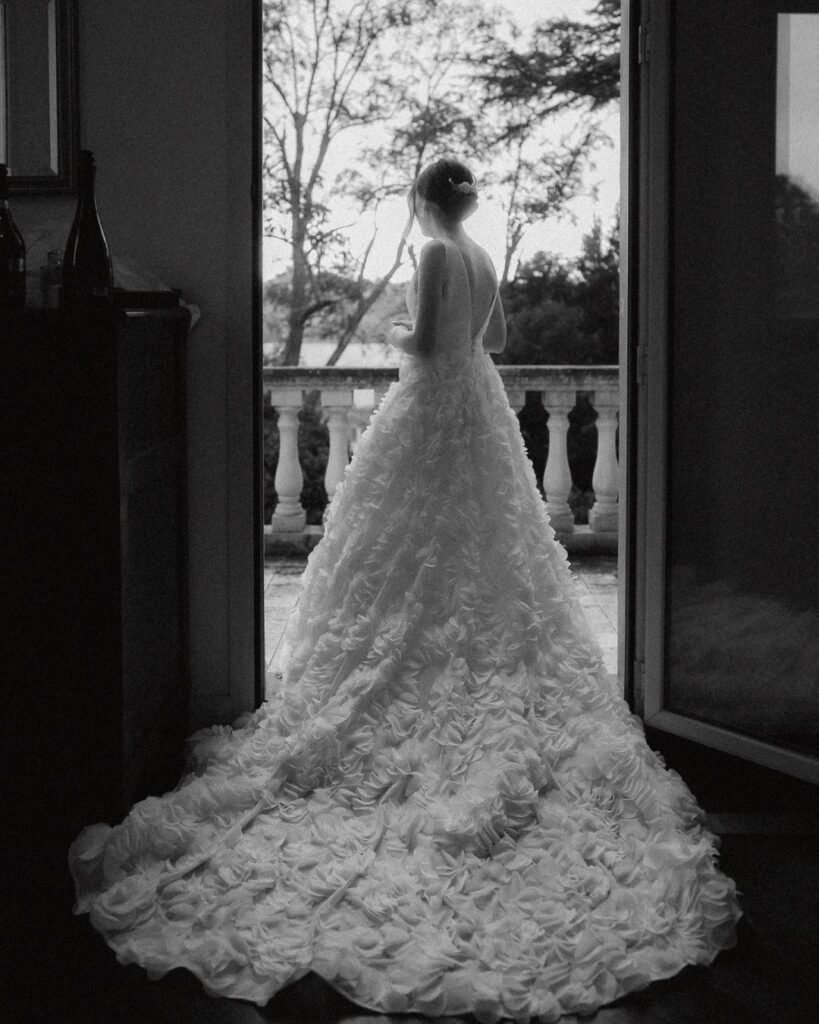The bride poses in an arched doorway at Villa Donna Camilla, framed by historic stone walls.