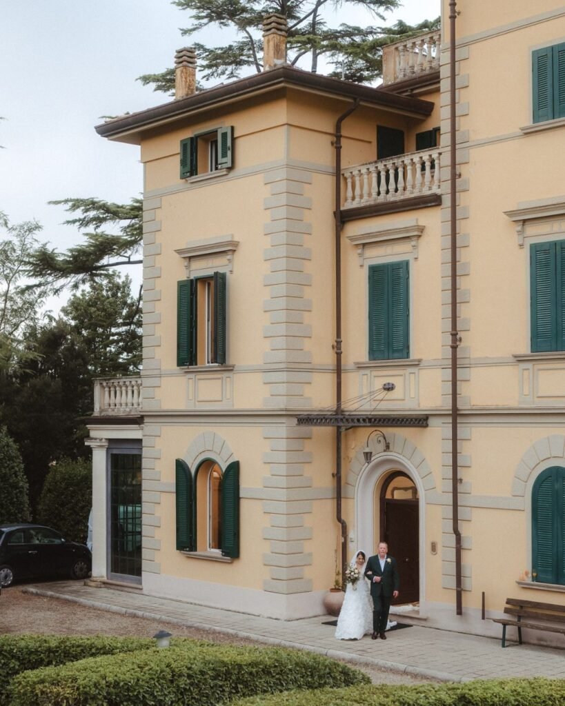 The grand entrance of Villa Donna Camilla, framed by historic architecture and lush greenery.