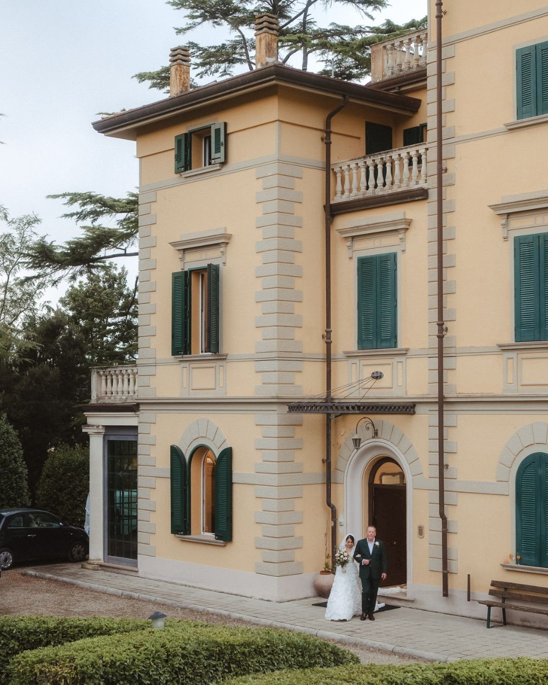 The grand entrance of Villa Donna Camilla, framed by historic architecture and lush greenery.