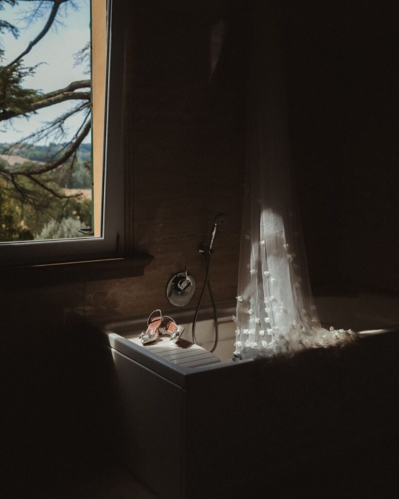A delicate bridal veil and designer shoes elegantly placed in a vintage bath at Villa Donna Camilla.
