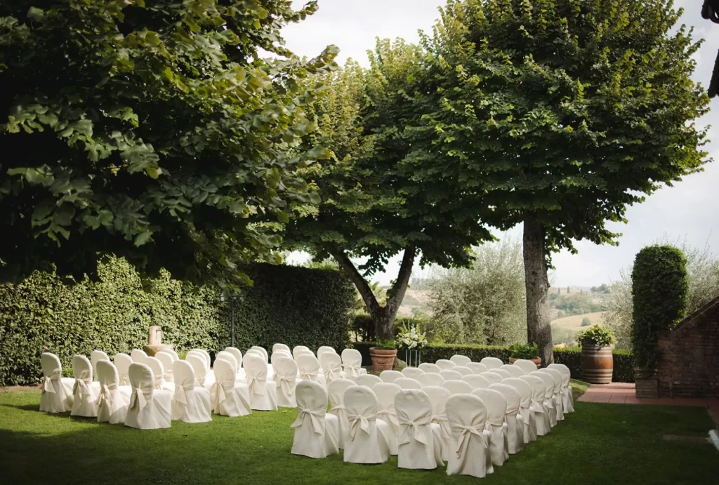 Outdoor wedding ceremony space at Borgo Tre Rose shaded by trees and surrounded by nature.