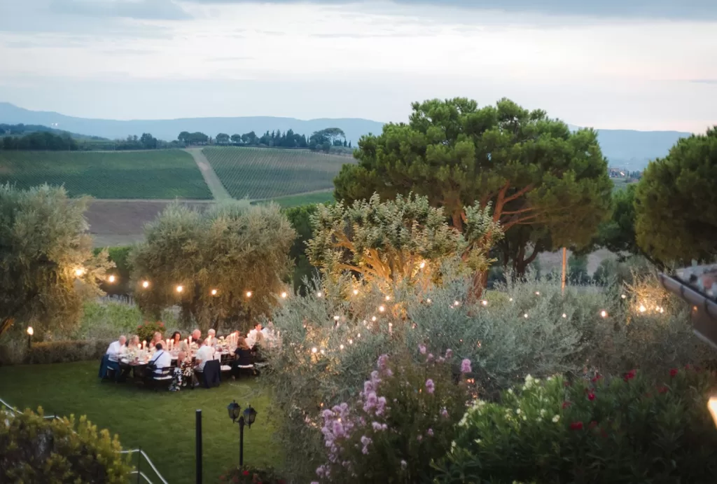 Evening wedding reception under fairy lights surrounded by olive trees at Borgo Tre Rose.