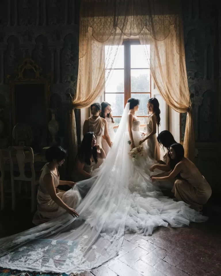 The bride shares a joyful moment with her bridesmaids in the elegant setting of Villa di Geggiano