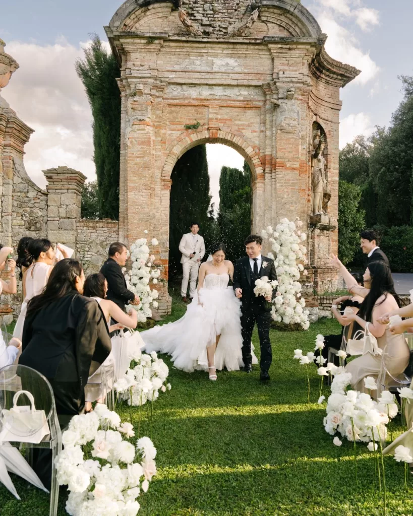 The bride’s veil catches the wind as she stands in the gardens of Villa di Geggiano.