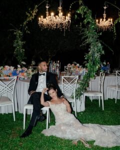The couple shares a quiet moment under chandeliers at Castello Montignano, with the bride resting against the groom in her floral gown.
