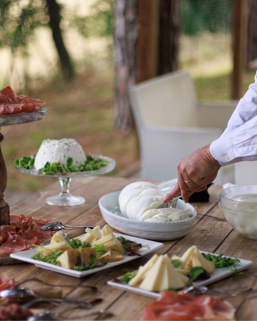 Rustic Italian cheese and charcuterie table at Castello Montignano, with fresh mozzarella being sliced for guests.