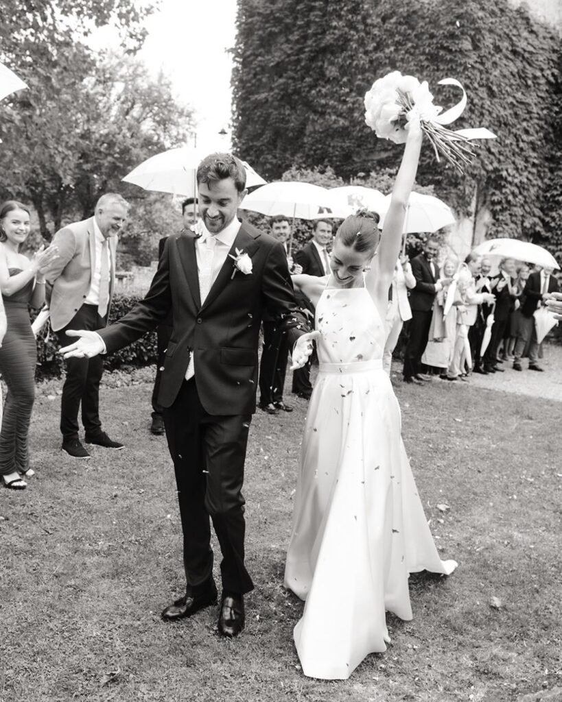 Couple smiling as guests throw confetti at their Château Rigaud wedding.