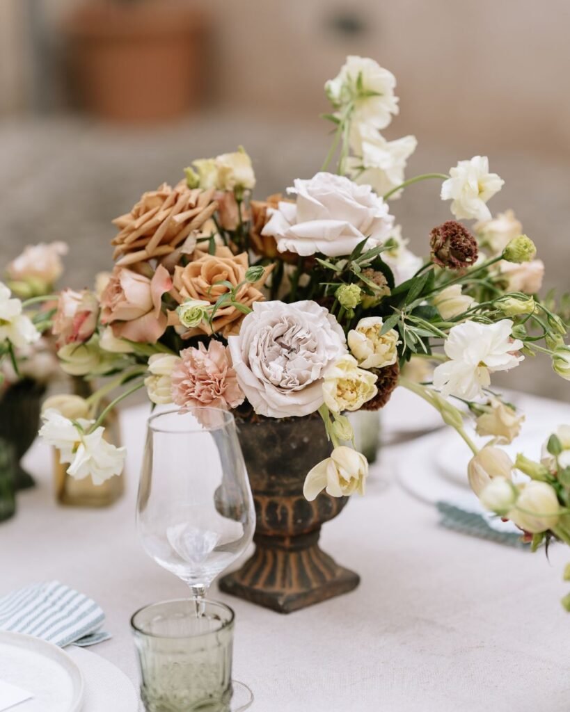 Romantic floral centerpiece in neutral tones placed elegantly on the reception table at Finca Morneta wedding.